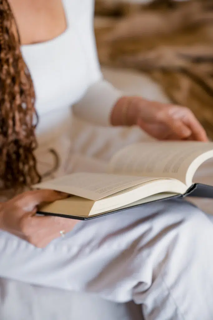 Woman with open book in lap.