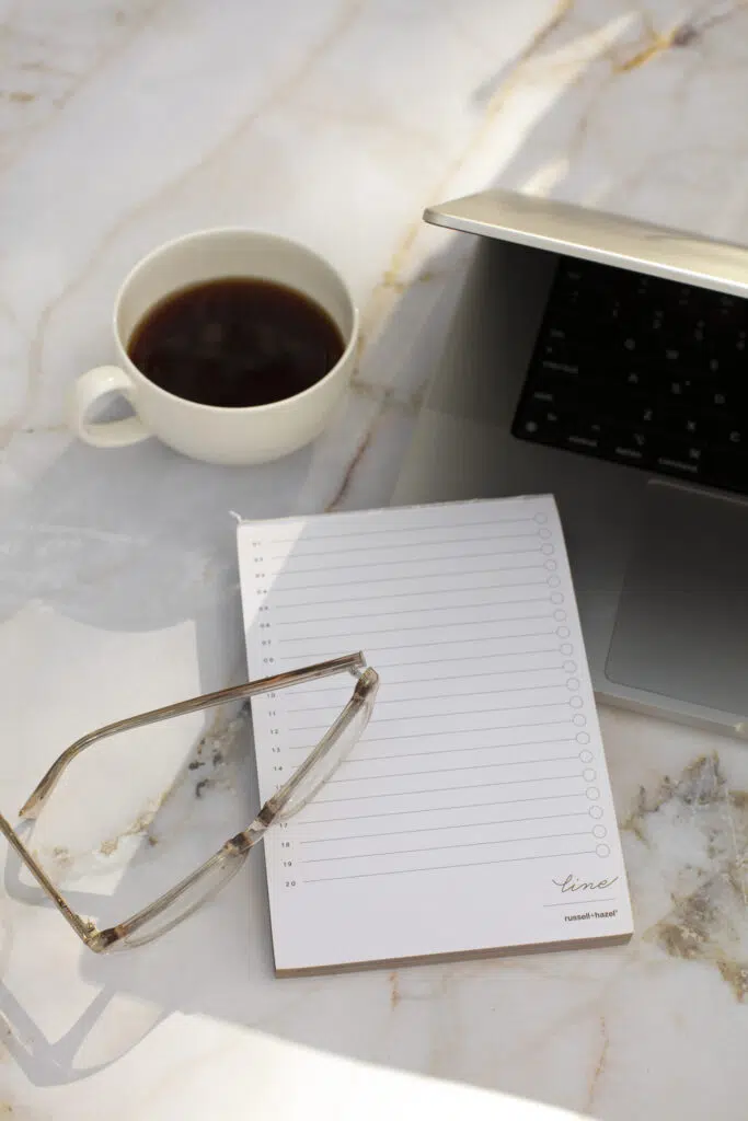 A teacher planner is more than just a to do list. Image of coffee, laptop, eyeglasses, and blank numbered to-do list.