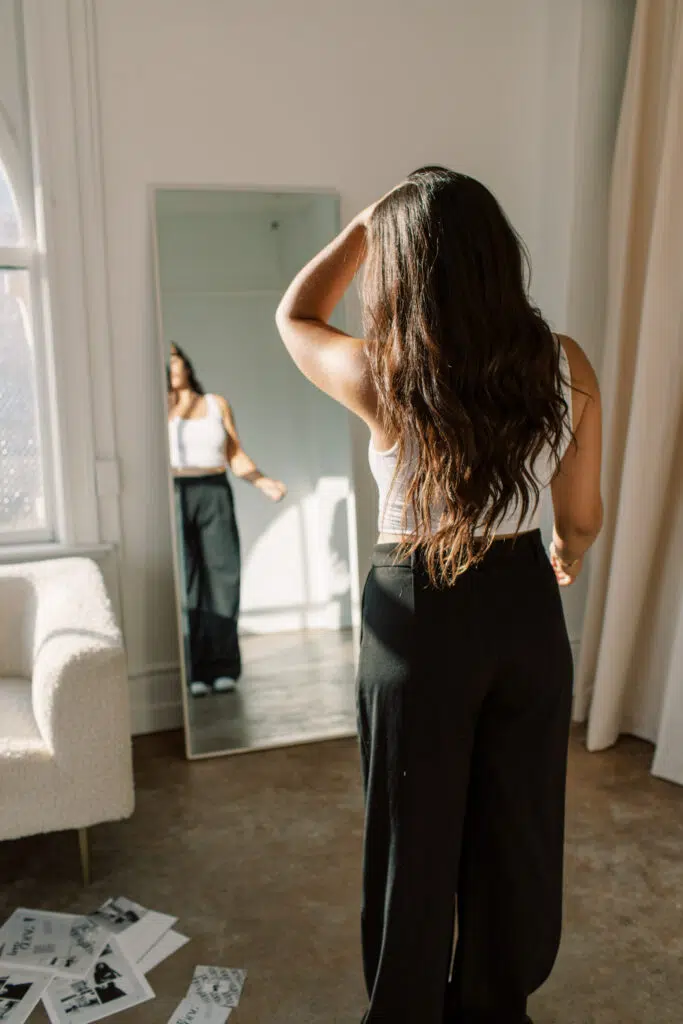 Building a cultural toolkit woman looking at herself in full length mirror.