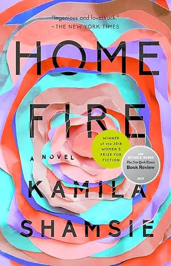 Book cover of “Home Fire” by Kamila Shamsie. The design features layered, cut-paper rings in bright colors—pink, coral, teal, orange, and purple—forming a stylized flower or vortex shape. Award badges overlap the center-right area.
